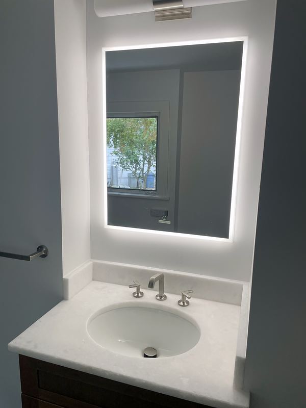 Backlit mirror over white vanity