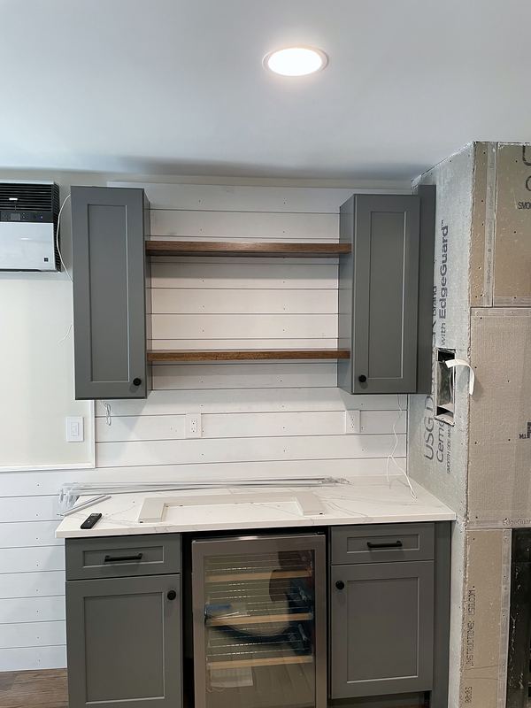 Gray cabinets with open wood shelving and wine fridge