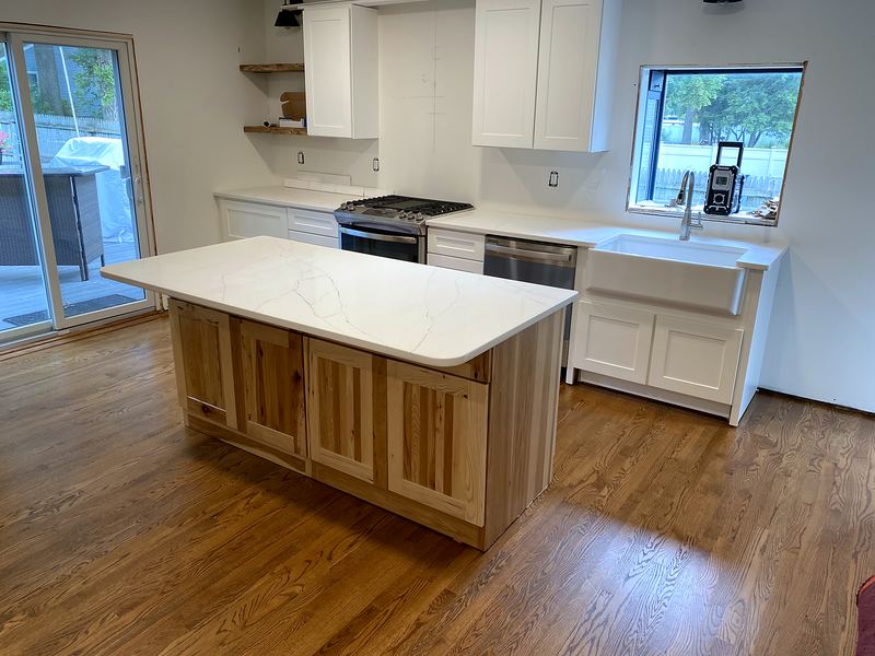 White shaker kitchen with natural wood island and quartz top