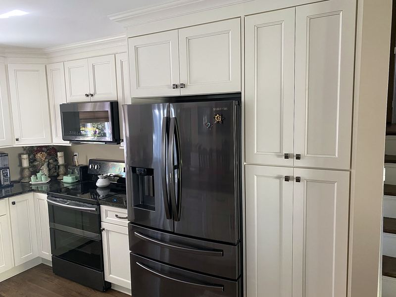 White shaker kitchen with black countertops and stainless appliances